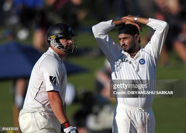 Indian cricketer Harbhajan Singh reacts as New Zealand batsman Jesse Ryder looks on during the first day of the second Test match at the McLean Park...