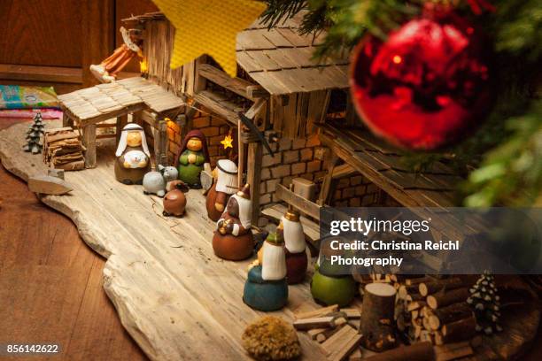 crib under german christmas tree - weihnachtskrippe stock-fotos und bilder