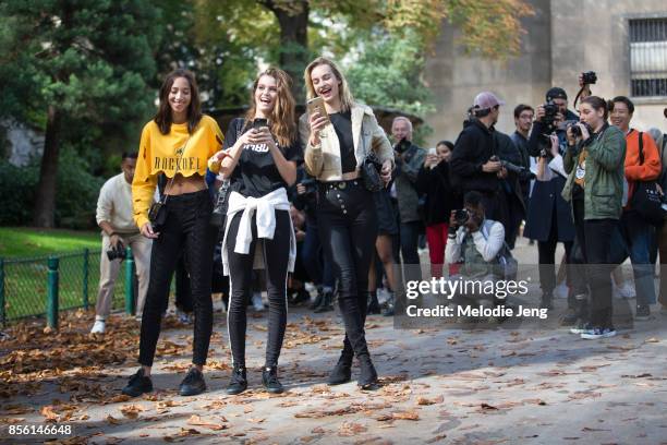 Dutch models Yasmin Wijnaldum, Luna Dijl, Maartje Verhoef laugh and take photos of the photographers outside the Mugler show on September 30, 2017 in...