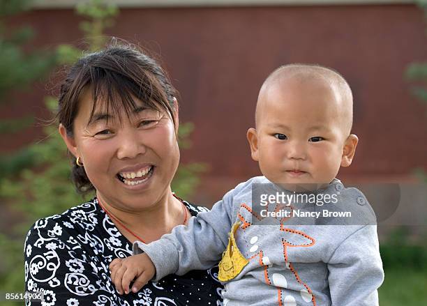 inner mongolian mother holding baby in grasslands - abagnar qi foto e immagini stock