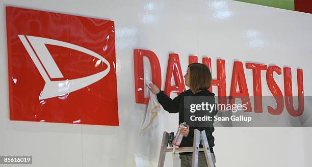 Worker polishes a logo at the Daihatsu stand at the AMI 2009 International Auto Fair on March 26, 2009 in Leipzig, Germany. The trade fair will be...