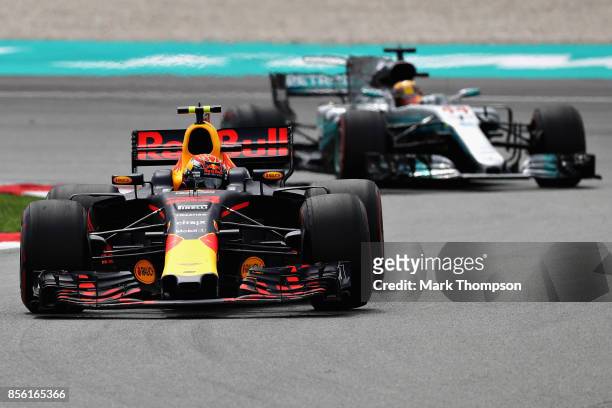 Max Verstappen of the Netherlands driving the Red Bull Racing Red Bull-TAG Heuer RB13 TAG Heuer leads Lewis Hamilton of Great Britain driving the...