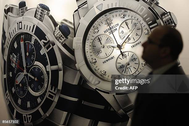 Man passes by a poster of a watch at the Baselworld 2009 watch and jewellery show on March 26, 2009 in Basel. The glittering watch and jewellery...