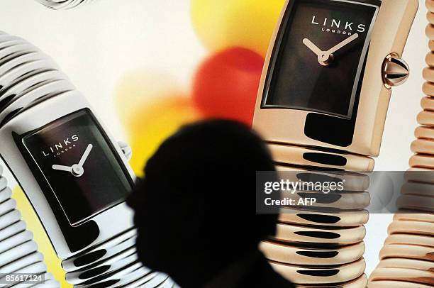Man passes by a poster of Link's watches at the Baselworld 2009 watch and jewellery show on March 26, 2009 in Basel. The glittering watch and...