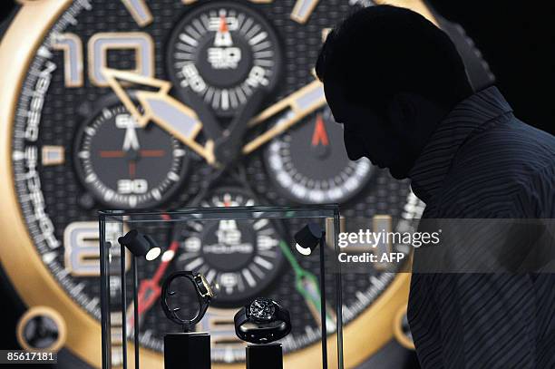 Man looks at exposed watches on Porsche's stand at the Baselworld 2009 watch and jewellery show on March 26, 2009 in Basel. The glittering watch and...