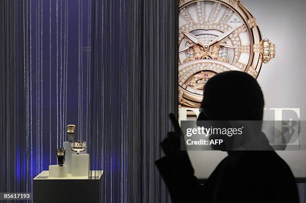 Man passes by a poster of a watch at the Baselworld 2009 watch and jewellery show on March 26, 2009 in Basel. The glittering watch and jewellery...