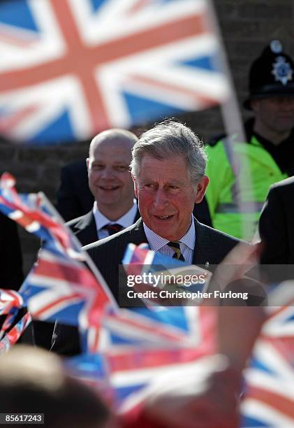 Prince Charles, the Prince Wales greets flag waving school children during his visit to the Blacon Community Trust on March 26, 2009 in Chester,...