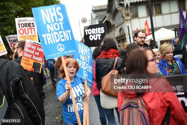 An anti-nuclear protester hands out placards at an anti-austerity demonstration organised by The People's Assembly in Manchester to coincide with the...