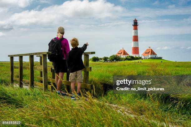 frau und jungen suchen zum leuchtturm westerhever - deutsche nordseeregion stock-fotos und bilder