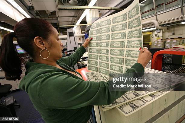 Angela Jones inspects sheets of soon to be one dollar bills before they are cut into singles at the Bureau of Engraving and Printing on March 26,...