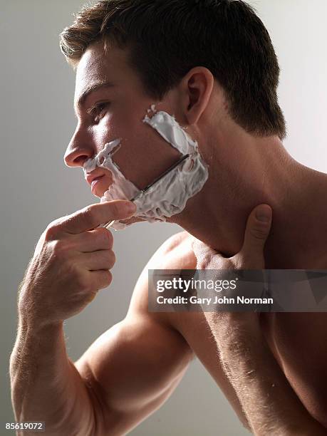 young man, shaving using cut-throat razor. - man shaving foam stock pictures, royalty-free photos & images