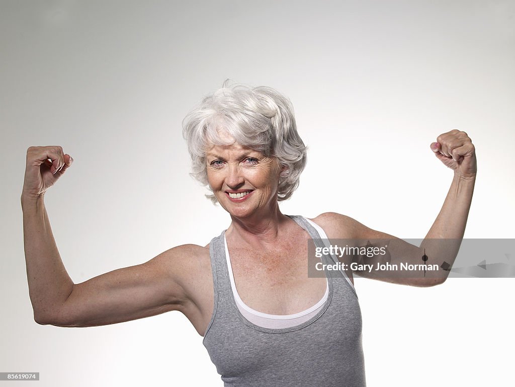  Senior woman flexing muscles, smiling, portra