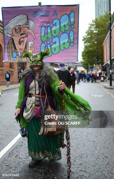 Protester carries an anti-Theresa May placard during an anti-austerity demonstration organised by The People's Assembly in Manchester to coincide...