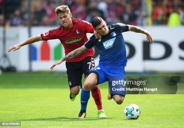 Florian Niederlechner of SC Freiburg challenges Lukas Rupp of 1899 Hoffenheim during the Bundesliga match between Sport-Club Freiburg and TSG 1899...