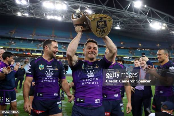 Cooper Cronk of the Storm walks off the field with team mates Billy Slater and Cameron Smith after winning the 2017 NRL Grand Final match between the...