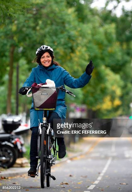 Paris' mayor Anne Hidalgo arrives at place de la Bastille on a bicycle to attend the "car free" day in Paris on October 1, 2017. - Parisians were...