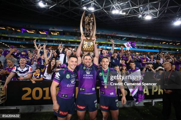 Cooper Cronk, Cameron Smith and Billy Slater of the Storm pose with the Provan-Summons Trophy after winning the 2017 NRL Grand Final match between...