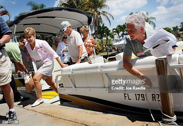 Les Renkey holds the rope to a mooring as others looking to buy a home at a good price get off the boat as they take part in a foreclosure boat tour...