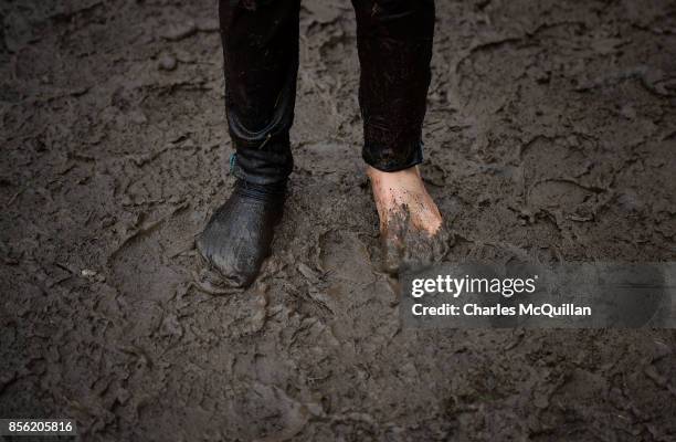 Young competitor stands shoesless and missing a sock after the McVities Jaffa Cakes Mud Madness kids race in association with charity partner Marie...
