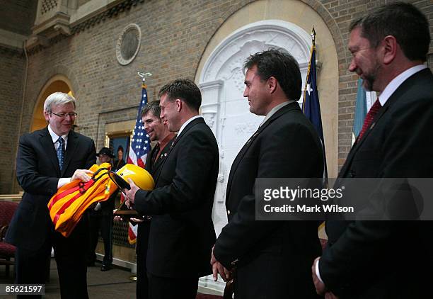 Australia Prime Minister Kevin Rudd presents Eric Bush , Tony Johnson , Bodie Shaw and Alan Goodwin with an Australian firefighter suit during a...