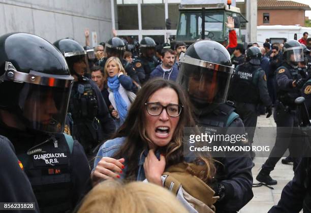 People clash with Spanish Guardia Civil guards outside a polling station in Sant Julia de Ramis, where Catalan president was supposed to vote, on...