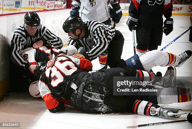 Linesmen David Brisebois and Jonny Murray try to pry apart Scott Hartnell and Darroll Powe, both of the Philadelphia Flyers, and Keith Ballard of the...