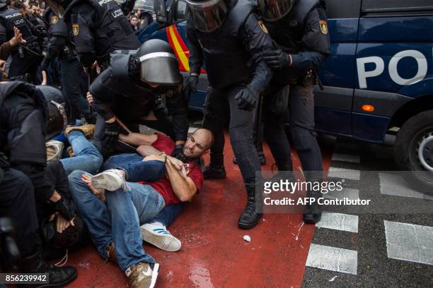 People clash with Spanish police officers outside the Ramon Llull polling station in Barcelona October 1, 2017 during a referendum on independence...