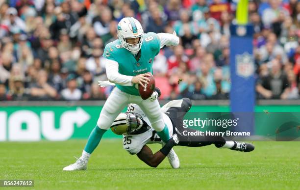 Jay Cutler of the Miami Dolphins is tackled by Rafael Bush of the New Orleans Saints in the first half during the NFL game between the Miami Dolphins...