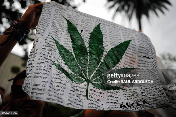 Demonstrator holds a marijuana leaf banner during a protest in defense of the non-criminalization of the so-called "personal dose" in Medellin,...