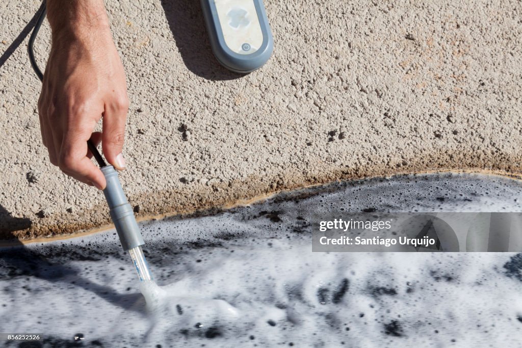 Scientist measuring the ph on a contaminated river