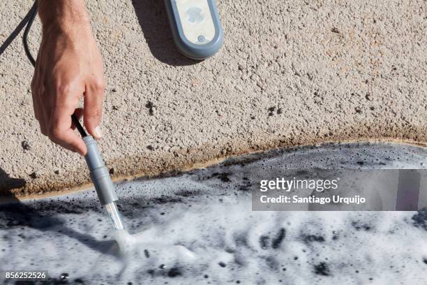 scientist measuring the ph on a contaminated river - acid rain stock pictures, royalty-free photos & images