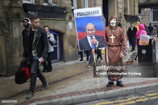 Man dressed up in a mask and holding a sign with Vladimir Putin on it saying 'Peacemaker' takes part in anti-Brexit and anti-austerity protests as...