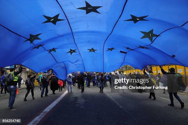An European Union flag is held up as people take part in anti-Brexit and anti-austerity protests as the Conservative party annual conference gets...