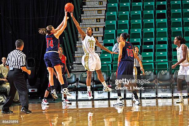 Porche Grant of the South Florida Bulls blocks Elizabeth Robertson of the Mississippi Rebels during the Women's National Invitational Tournament game...