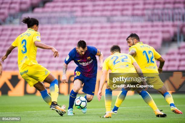 Lionel Messi of FC Barcelona conducts the ball between Pablo Lemos , Ximo Navarro and Michel Macedo of UD Las Palmas during the La Liga match between...