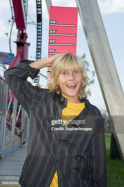 boy measuring his height at fair - lang lichaamslengte stockfoto's en -beelden