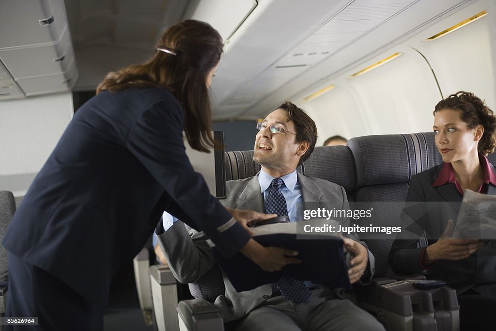 Stewardess handing blanket and pillow to passenger