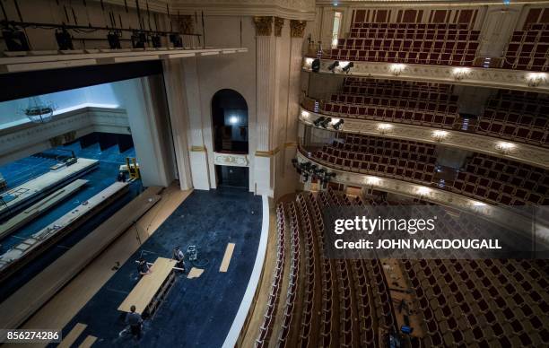Carpenters build sets on the stage in the main hall of Berlin's Staatsoper on October 1 prior to its official re-opening on October 3 after a 7-year...
