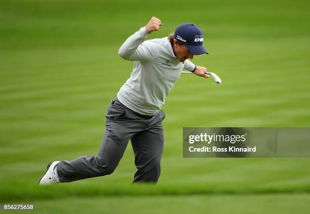 Paul Dunne of Ireland celebrates after chipping in on the 18th hole to win the tournament during day four of the British Masters at Close House Golf...