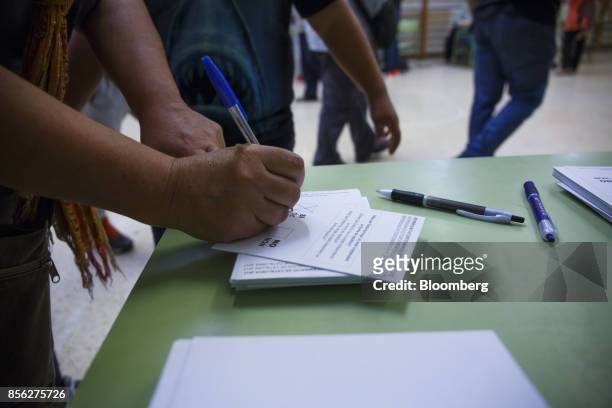 Woman marks her ballot at Escola La Font, an occupied school used as a polling station for the banned referendum, in Manresa, Spain, on Sunday, Oct....