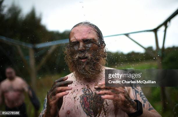 Runners shower after completing their race during the McVities Jaffa Cakes Mud Madness race in association with charity partner Marie Curie at...