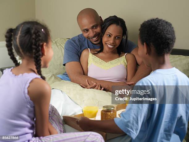 children and parents sitting in bed - mother's day breakfast stock pictures, royalty-free photos & images