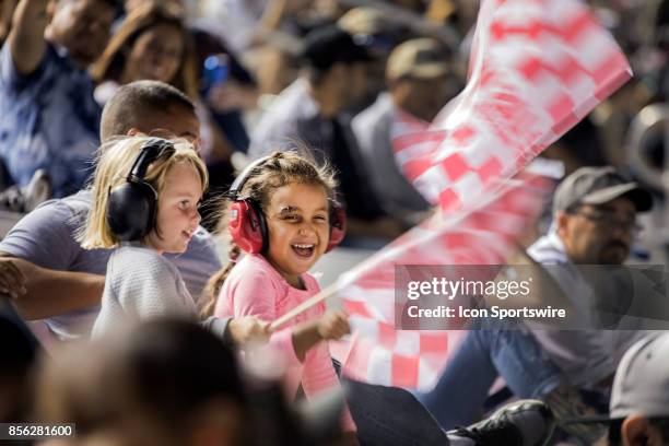 Young fans wave flags during the Las Vegas 350 NASCAR Camping World Trucks Series playoff race on September 30, 2017 at Las Vegas Motor Speedway in...