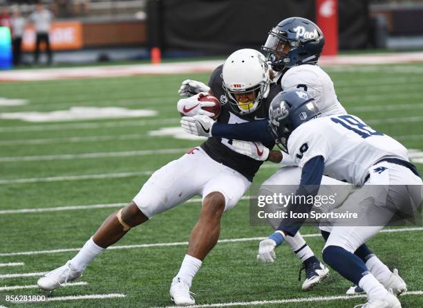 Washington State Cougars wide receiver Isaiah Johnson-Mack is taken down by Nevada Wolf Pack defensive back Asauni Rufus and defensive back Elijah...