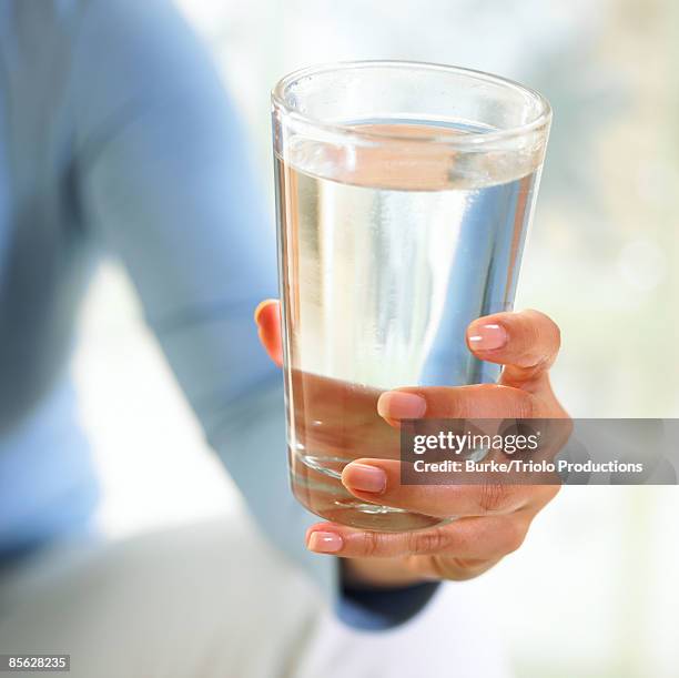hand holding glass of water - glas stockfoto's en -beelden