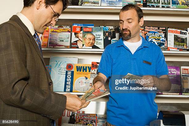 businessman purchasing item at newspaper stand - newsstand foto e immagini stock