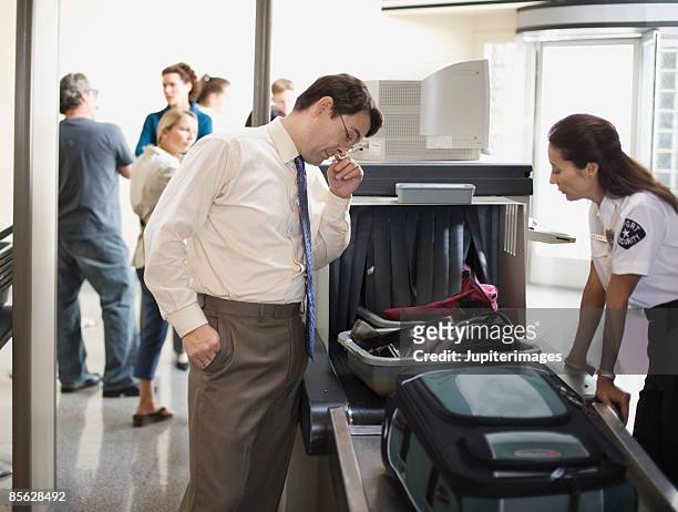 businessman and security officer at airport security checkpoint - guard stock-fotos und bilder