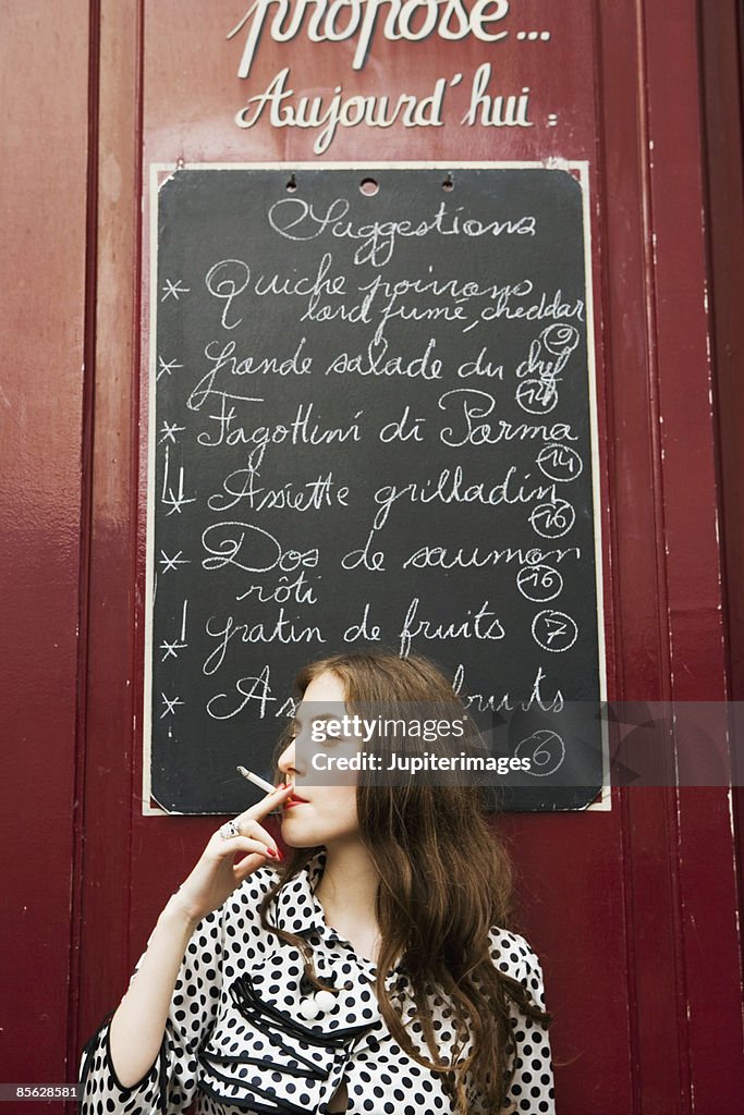 Woman smoking outside of cafe