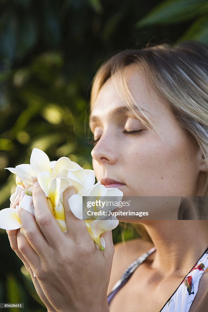 Woman smelling plumeria