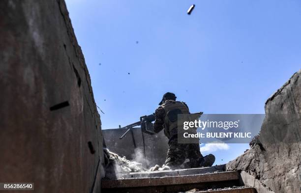 Member of the Syrian Democratic Forces fires his machine gun during clashes with Islamic State group jihadists near the central hospital of Raqa on...